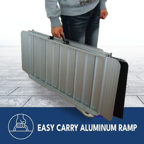 Person carrying a folded Heeve Aluminium Ramp with a convenient handle, showcasing its portability and easy-to-carry design. The ramp is compact and lightweight, making it ideal for transportation and storage, with a sturdy aluminium build for durability