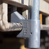 Side view of a flatbed truck equipped with safety guardrails along its sides.