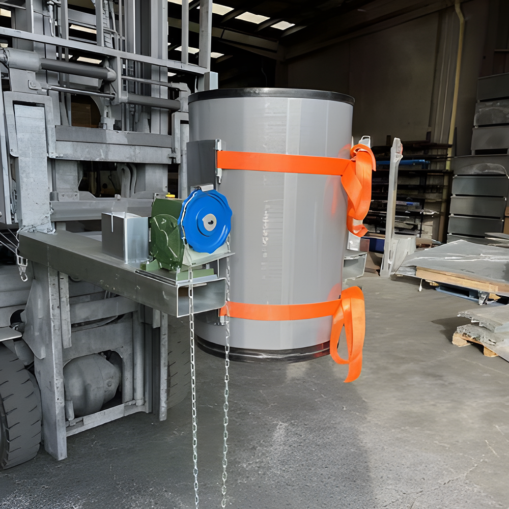 The drum rotator in an industrial setting, securely holding a drum with an orange safety strap, ready for tilting or pouring operations.