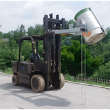 A forklift using the drum rotator to pour liquid from a steel or plastic drum outdoors. The drum is securely fastened, and the liquid is being dispensed with precision.

