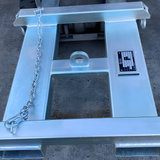 View from above showing the H-shaped forklift bulk bag carrier, with chain and hook secured, and a metal data plate visible