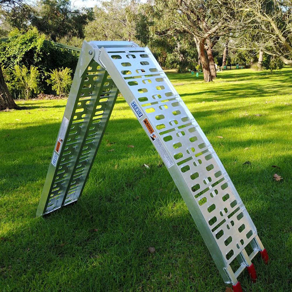 Side view of the aluminium ramp in an A-frame configuration, positioned on a grassy lawn.