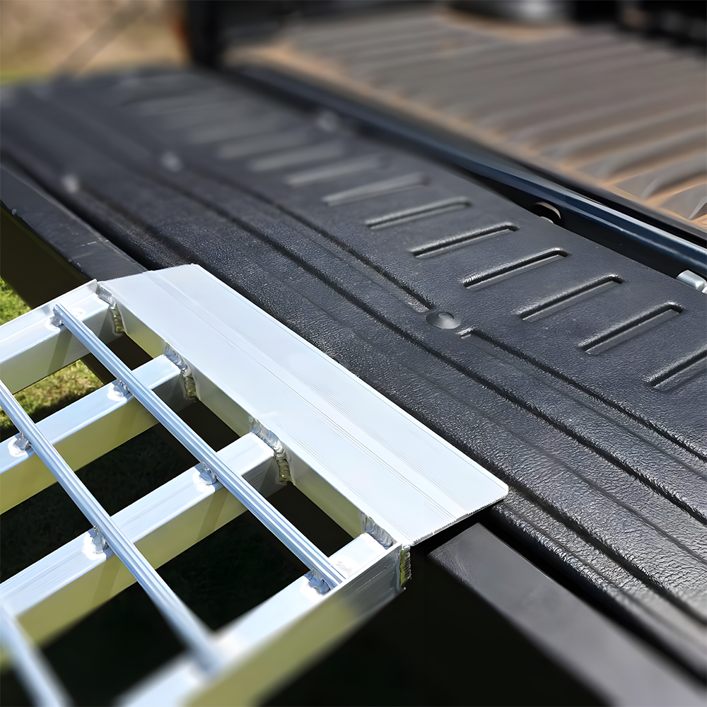 Close-up of the reinforced aluminium loading ramp securely positioned on the tailgate of a vehicle, highlighting the ramp's durability and strong attachment