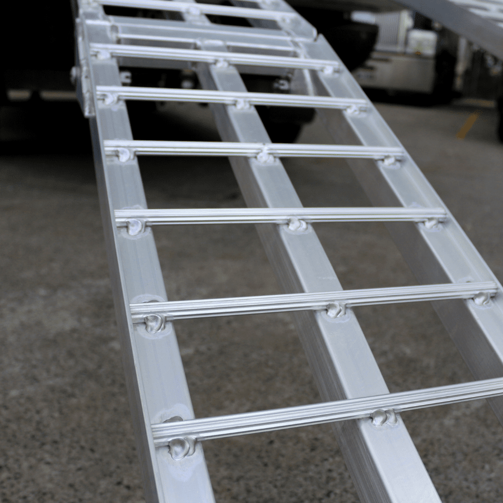 "Detailed view of a standard aluminium loading ramp, highlighting the welds and the sturdy construction of the crossbars."