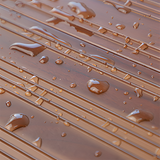 A detailed shot of a brown aluminium threshold ramp surface with water droplets, illustrating its water-resistant feature.