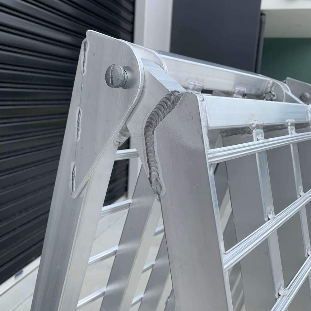 A close-up image of the folding hinge of the Heeve loading ramp, highlighting the secure welded joint and pin mechanism for easy folding