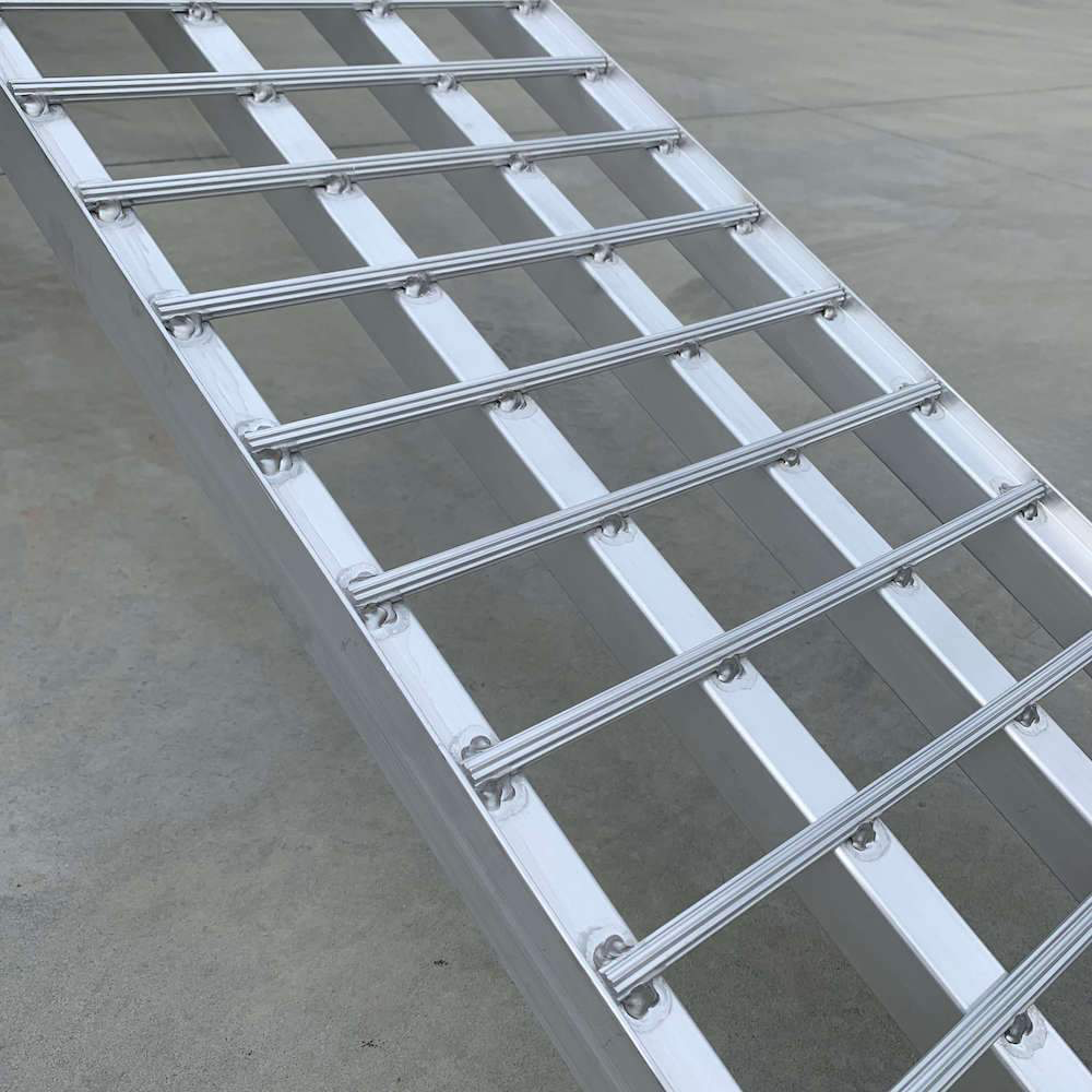 A side view of the Heeve ramp with emphasis on its curved, non-slip aluminium bars designed for safer loading and unloading.