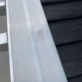 Close-up view of the reinforced edge of an aluminium loading ramp, showing its sturdy construction against the backdrop of a truck bed