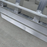 Close-up view of the reinforced end of an aluminium loading ramp, highlighting the robust welding and textured surface for secure grip