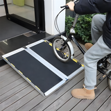 Close-up of a person on a bike using the Heeve single-fold ramp to enter a building, highlighting its safe entry angle and stability