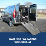 The Heeve Deluxe Multi-Fold Aluminium Wheelchair Ramp deployed from the back of a silver van, allowing a wheelchair to be smoothly rolled inside