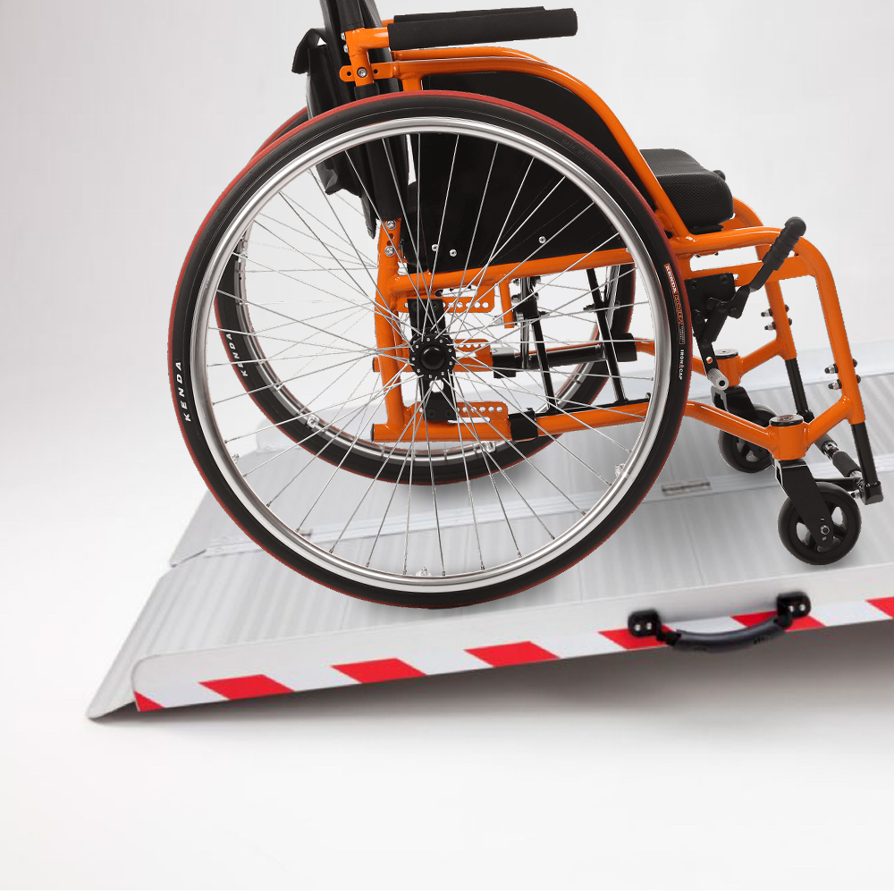 Aluminium wheelchair ramp in use, showing a wheelchair smoothly rolling onto the ramp from a low incline