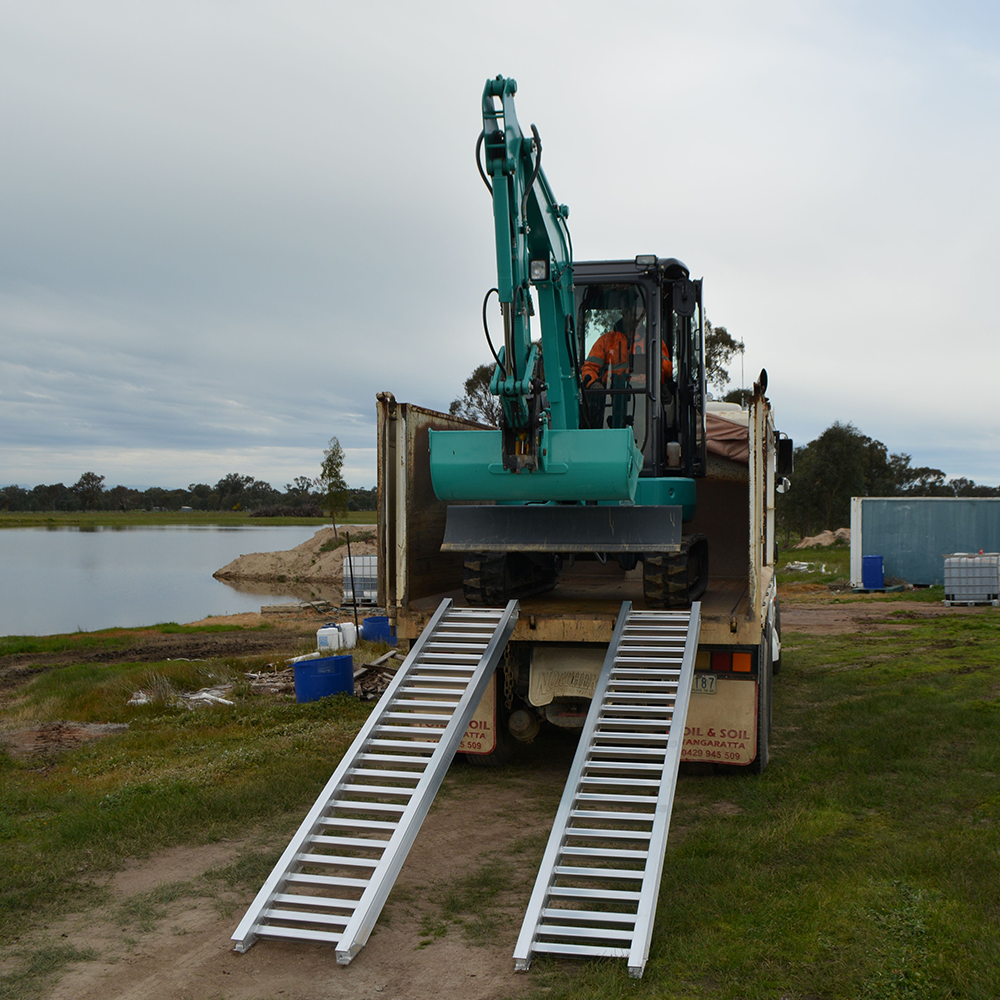 excavator on top of the ramp installed on the truck