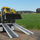 backhoe on the Sureweld 1.5-Tonne 2.4m x 390mm Rubber Series Aluminium Loading Ramps