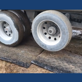 Truck wheels on mud on the Heeve Traction Guard Vehicle Access Mat