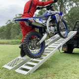 rider moving the motorcycle towards the back of the truck