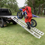 rider using the walk ramp and motorcycle ramp to move his motorcycle towards the back of his truck