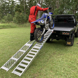 rider using the walk ramp and motorcycle ramp to move his motorcycle towards the back of his truck