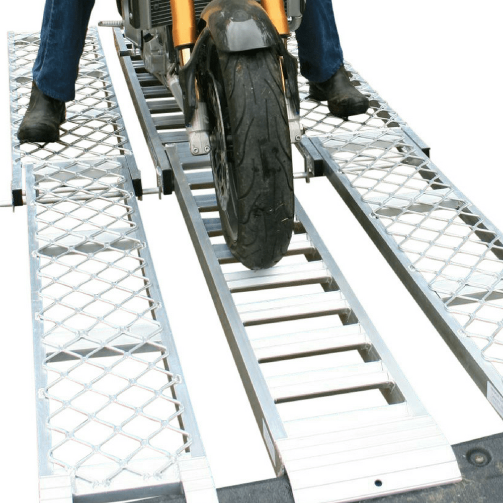 rider using the walk ramp and motorcycle ramp to move his motorcycle towards the back of his truck