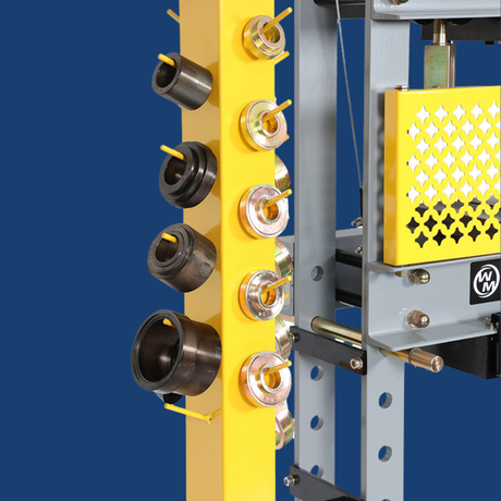 Close-up of the machine's side, showcasing multiple die holders with a vibrant yellow safety panel.